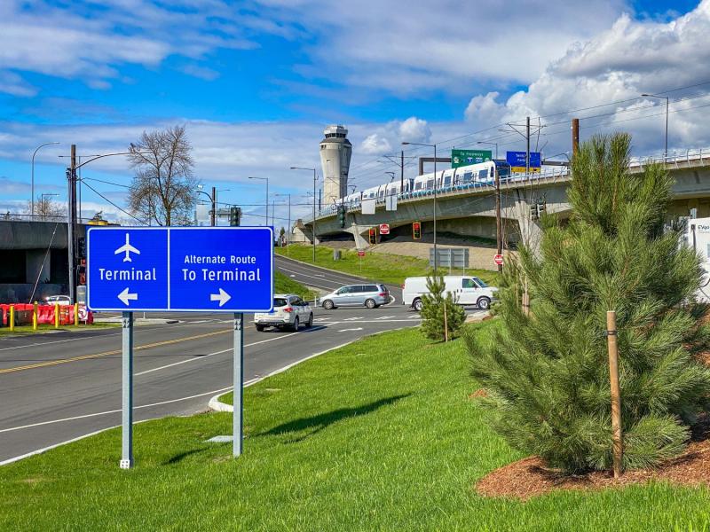 Road signs at the Cell Phone Lot with Link light rail in the background