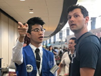 A pathfinder assists a customer in the departures terminal.