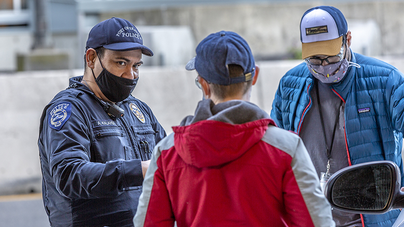 Police officer in uniform talking to motorists on the arrivals drive at SEA Airport April 2021