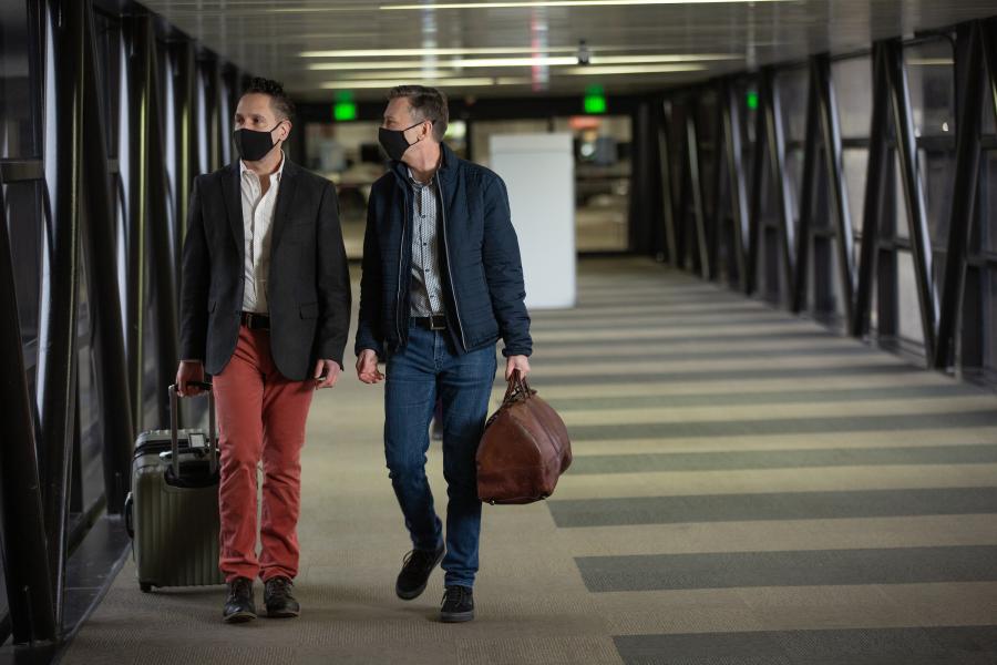 Travelers walking into the airport from parking garage 