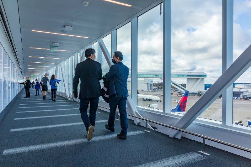 Two men wearing suits walk on the pedestrian walkway at the new IAF