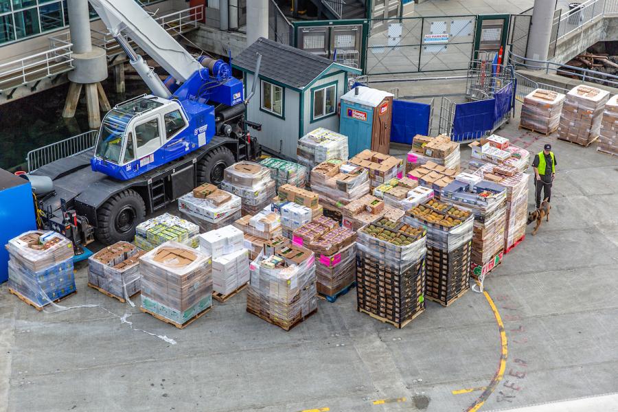 Cruise ship being loaded with fruits, vegetables, and flowers