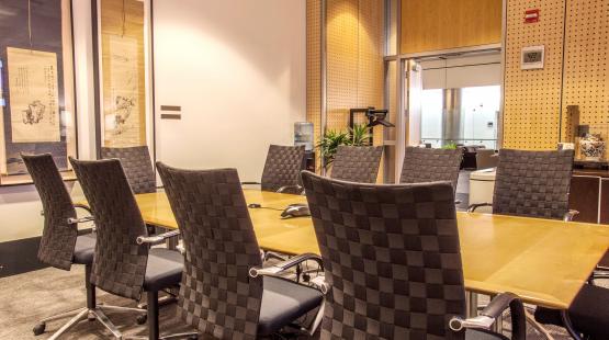 view of the Tokyo boardroom showing the wooden table, with 10 chairs set around the table.